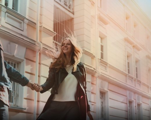 Couple qui se sourit et se tient la main dans la rue