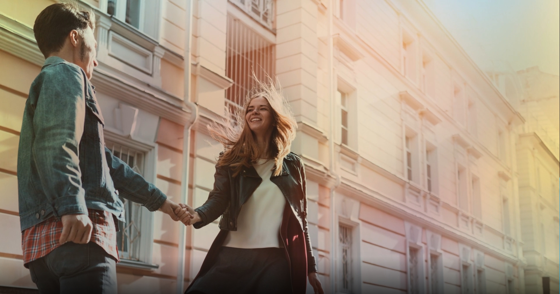 Couple qui se sourit et se tient la main dans la rue